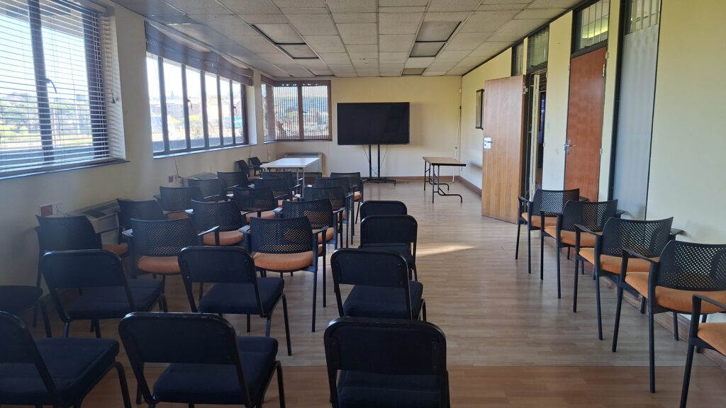 Training room with rows of chairs facing a wall-mounted screen