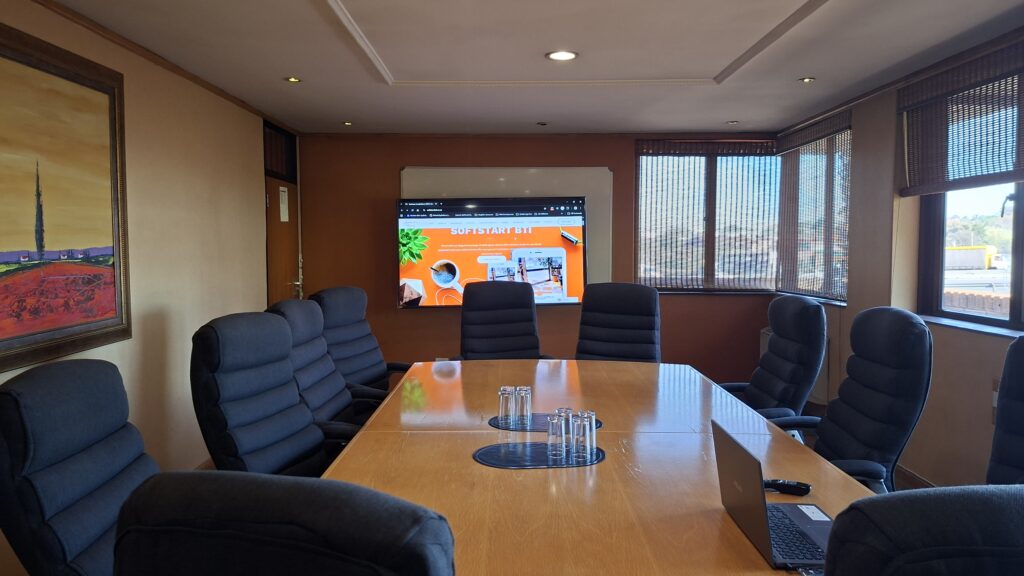 Boardroom table set up with a presentation on screen