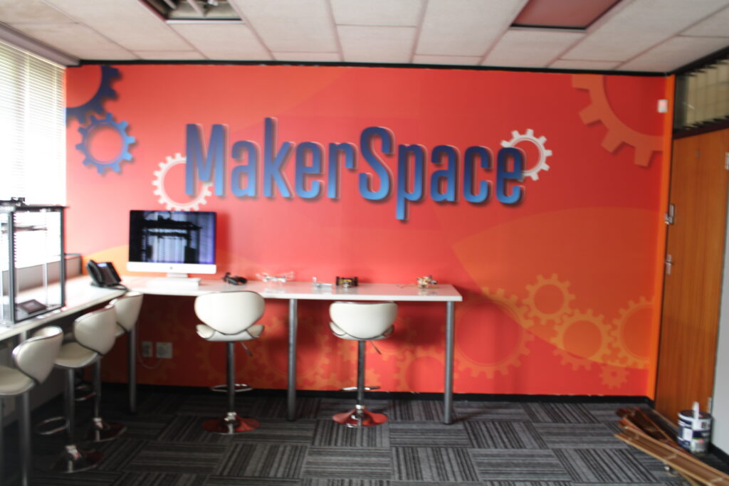 Maker-space with a branded orange MakerSpace feature wall