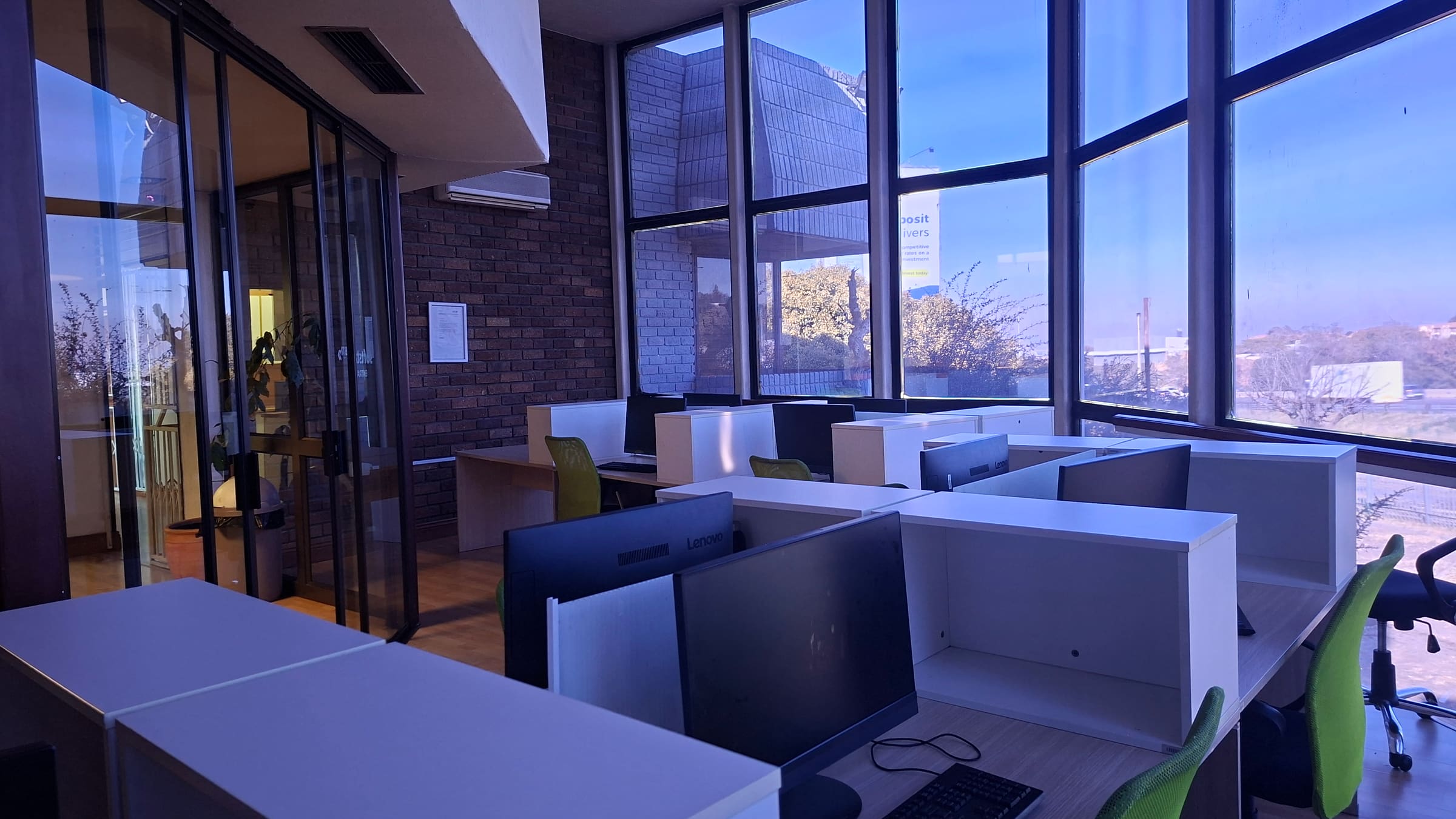 Open-plan workspace with desks and large windows at Softstart BTI